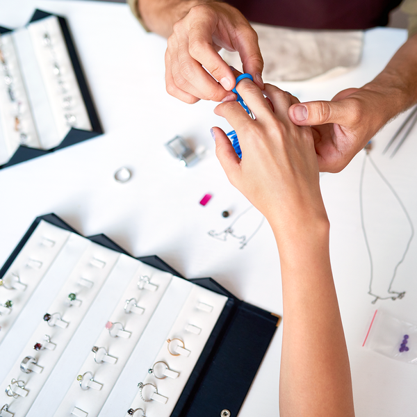 Jeweler sizing woman's hand 